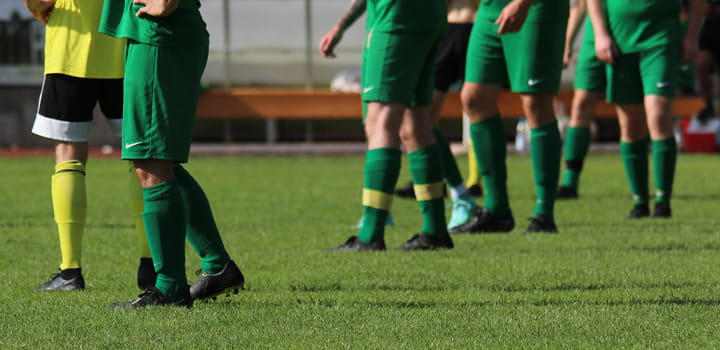 Fußballspieler auf Rasen während des Spiels als Motiv für Sportplatzberegnung und gleichmäßige Bewässerung der Spielfläche